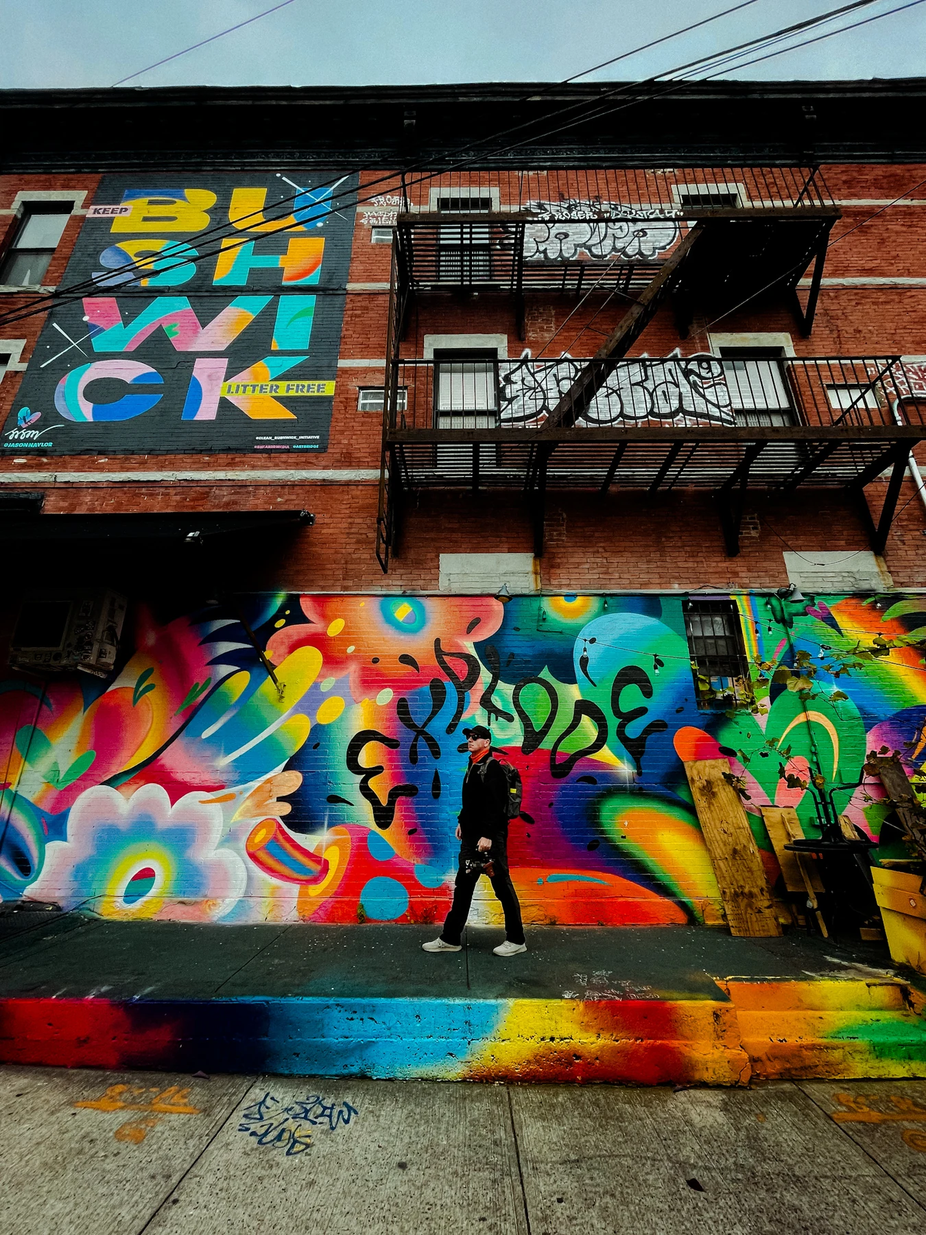 Matej in front of a colourful graffiti wall